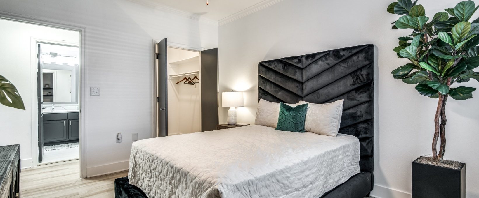 a bedroom with a black headboard and white walls at The The Brixton